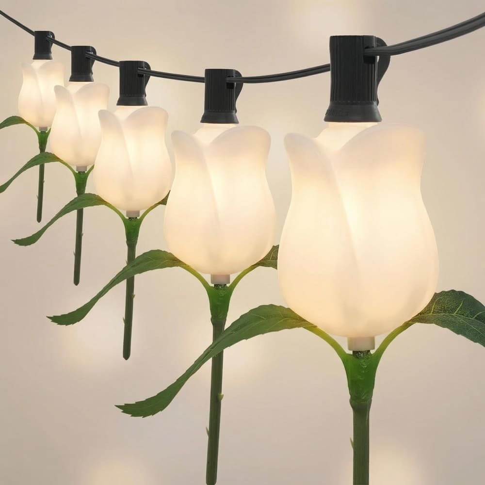 Warm white LED rose flower string lights with green leaves for elegant outdoor event decor