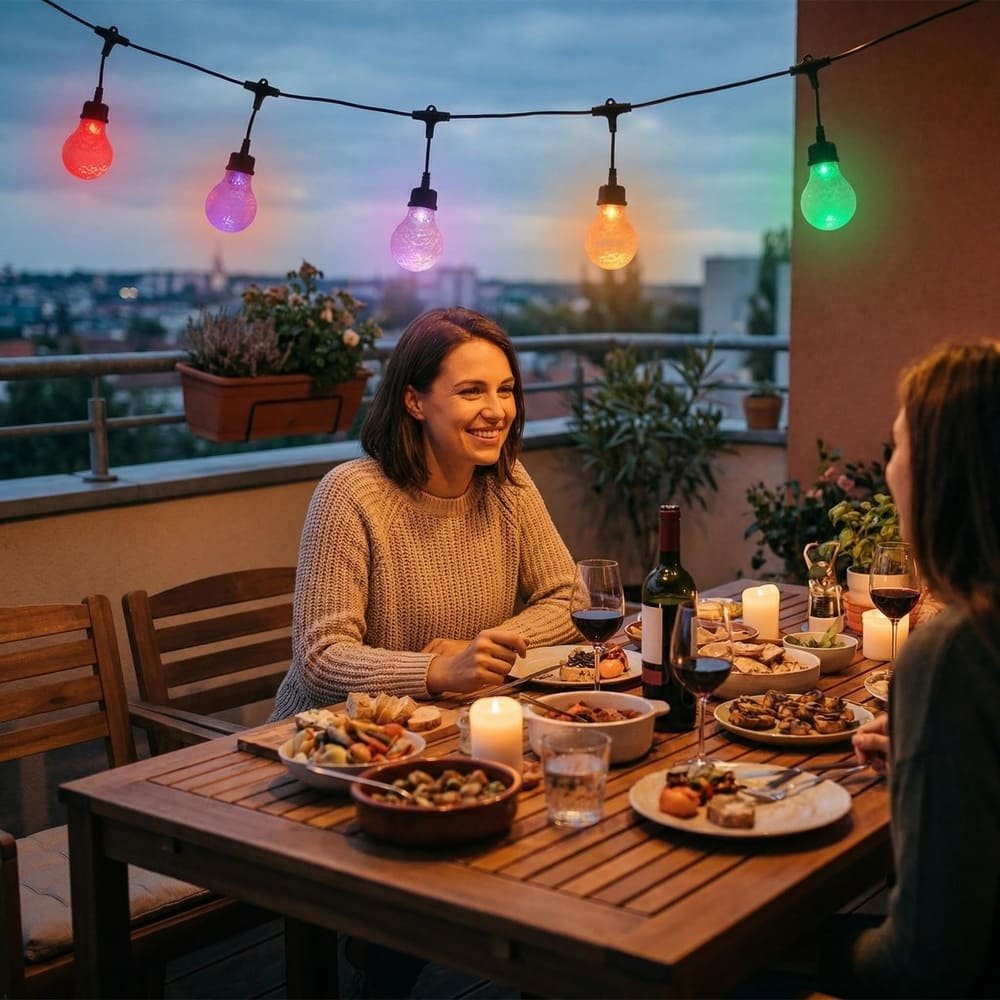 Outdoor balcony dining scene illuminated by vibrant RGB commercial drop string lights